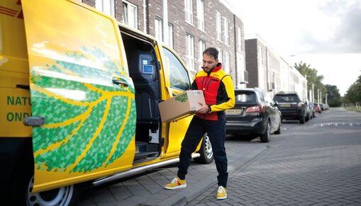 DHL courier taking parcel out of his delivery van